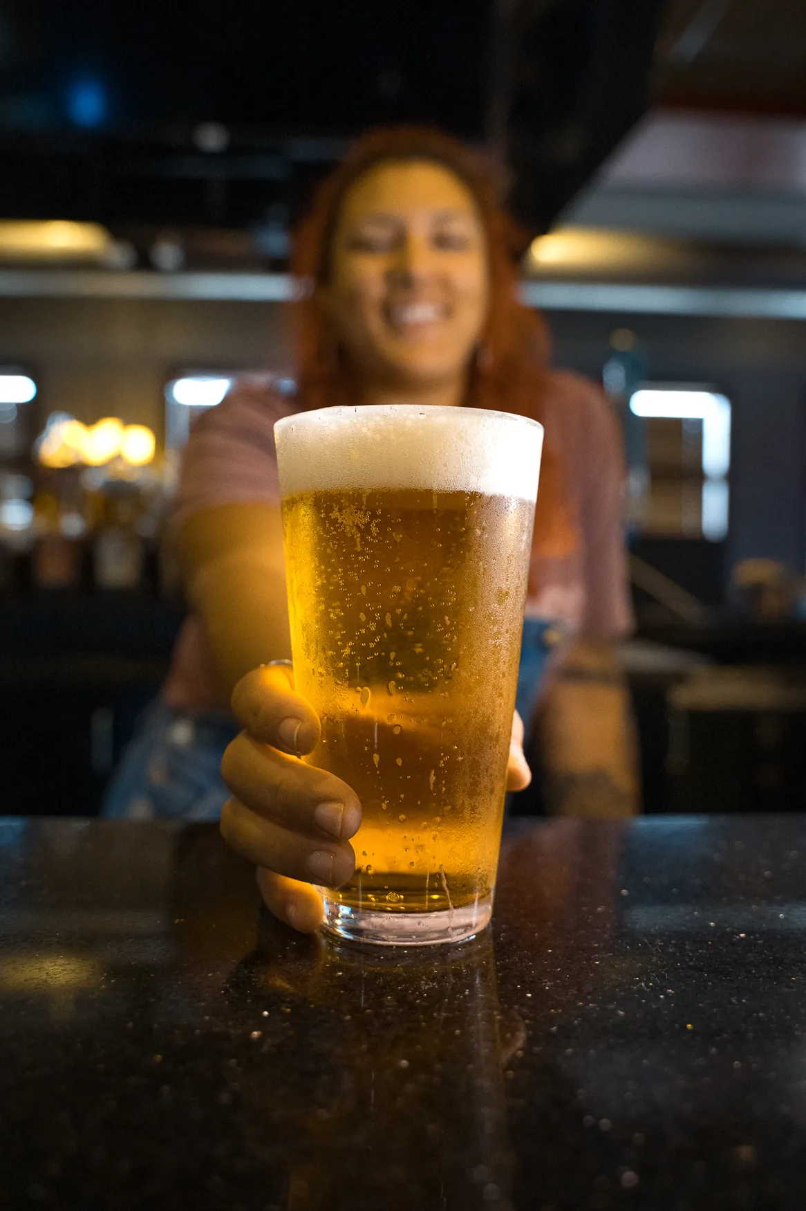 Your bartender handing over a cold draft beer at 212 Your bartender handing over a cold draft beer at 212