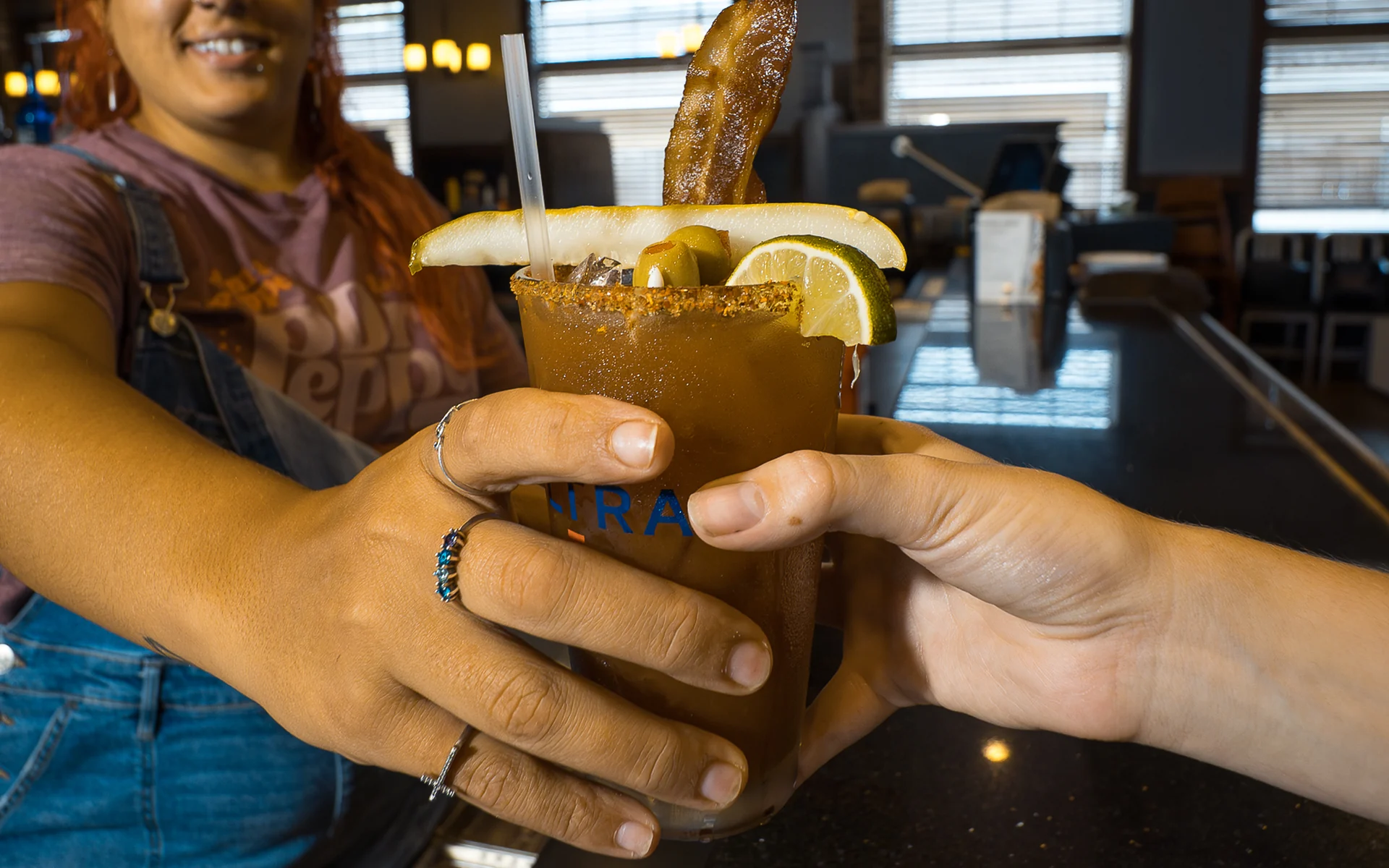 Pull up a chair at 212 The Boiling Point Two people toasting a bloody mary across the bar at 212