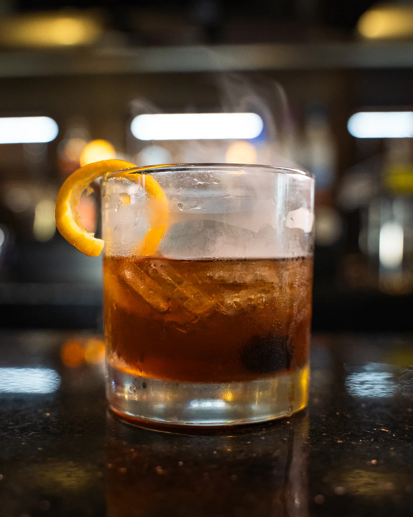 A smoked old fashioned with an orange twist on the bar at 212 A smoked old fashioned with an orange twist on the bar at 212