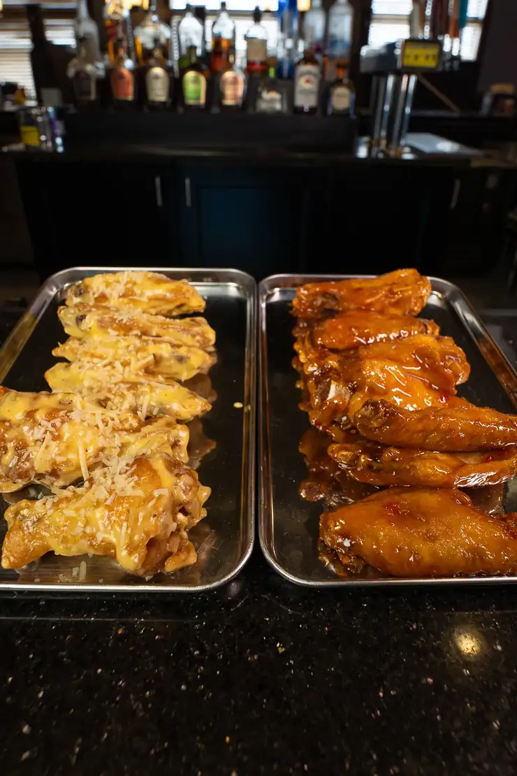 Two trays of house smoked wings, one garlic parmesan and one buffalo Two trays of house smoked wings, one garlic parmesan and one buffalo